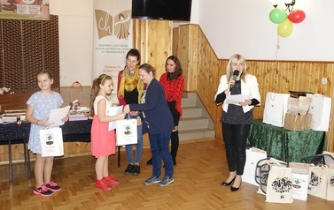 Na zdjęciu widzimy wręczanie nagr&oacute;d i dyplom&oacute;w laureatom przez dyrektora centrum kultury w konkursie rękodzielniczym w ramach projektu pn. Chorkowiecki Festiwal Rzemiosła