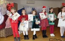 Na zdjęciu widzimy Świętego Mikołaja oraz dzieci z otrzymanymi prezentami w Domu Ludowym w Zręcinie