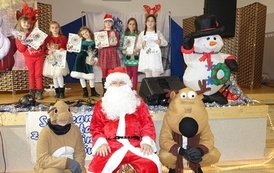 Na zdjęciu widzimy Świętego Mikołaja oraz dzieci z otrzymanymi prezentami w Domu Ludowym w Zręcinie