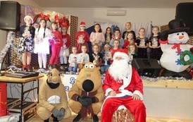 Na zdjęciu widzimy Świętego Mikołaja oraz dzieci z otrzymanymi prezentami w Domu Ludowym w Zręcinie