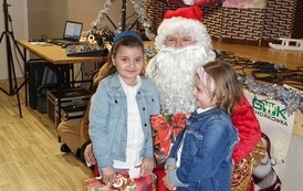 Na zdjęciu widzimy Świętego Mikołaja rozdającego prezenty dzieciom w Domu Ludowym w Zręcinie