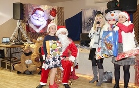 Na zdjęciu widzimy Świętego Mikołaja rozdającego prezenty dzieciom w Domu Ludowym w Zręcinie