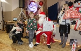 Na zdjęciu widzimy Świętego Mikołaja rozdającego prezenty dzieciom w Domu Ludowym w Zręcinie