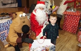 Na zdjęciu widzimy Świętego Mikołaja rozdającego prezenty dzieciom w Domu Ludowym w Zręcinie