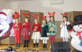 Na zdjęciu widzimy sz&oacute;stkę dzieci śpiewające piosenki o Świętym Mikołaju w Domu Ludowym w Zręcinie